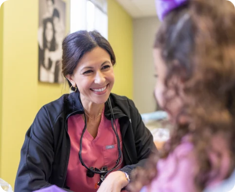 Dr. Mira Albert laughing with a young patient chairside